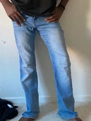 Ljusblå bootcut jeans  - Säljer ett par ljusblå jeans med utsvängd passform och klassisk femficksdesign. Jeansen har normal midja och är tillverkade i denim. Perfekta för en avslappnad och trendig look. Det finns defekter med jeansen som vissas på bilderna