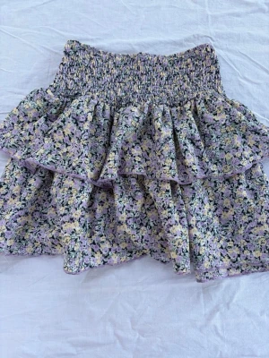 Blommig volangkjol från Gina Tricot - Färgglad blommig kjol i fina toner av lila, gul, svart och grön 🌸 I fint skick 🤍 Hör gärna av dig om du har några frågor!