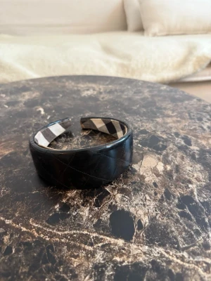 Svart diadem från Burberry - Snyggt svart diadem från Burberry med klassiskt rutigt tyg på insidan. Utsidan är i glansigt material! Supersnyggt