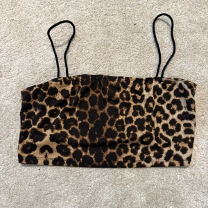 Leopardmönstrad linnetopp från SHEIN - Snygg leopardmönstrad linnetopp från SHEIN med tunna svarta axelband. Toppen har en croppad passform och är perfekt för dig som vill sticka ut. Tillverkad i mjukt syntetmaterial som känns bekvämt mot huden.