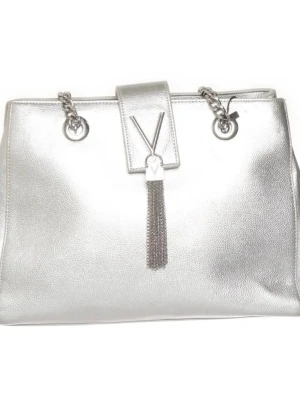 Silver handväska Vakentino med kedjedetaljer - Cool handväska i metallic silver med kedjedetaljer och axelrem. Väskan har en strukturerad form och stängs med ett lock framtill. Materialet är glansigt och ger ett trendigt intryck. Perfekt för dig som gillar att sticka ut med accessoarer. Flera fack inuti varav 2 delade större och 2 dragkedja + 3 mindre fack