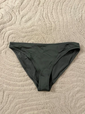 Mörkgrön bikiniunderdel - Säljer en mörkgrön bikiniunderdel i storlek S från H&M.