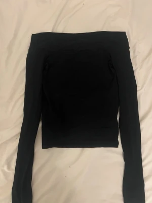 Svart offshoulder topp från BikBok - Säljer en svart offshoulder topp från BikBok i storlek XS. Toppen har långa ärmar och en tight passform som sitter snyggt över axlarna. Har fler bilder med tröjan på om intresserad🤗!!Om du köper välj gärna att hämta vid upphämtningsställe istället för hemleverans då det blir enklare för mig att posta på det viset!!