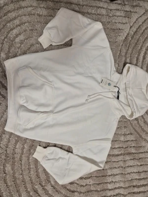 Vit hoodie med huva och magficka från BIKBOK - Klassisk vit hoodie från BIKBOK med stor magficka och dragsko i huvan. Tillverkad i mjukt material med ribbade muddar vid ärmslut och nederkant. Storlek xs. Perfekt för en avslappnad och bekväm look. Skriv gärna för prisförslag ❤️❤️