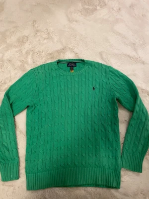 Grön kabelstickad tröja Polo Ralph Lauren - Snygg grön kabelstickad tröja från Polo Ralph Lauren. Sitter som xs/s. Hör av dig vid minsta lilla fundering!