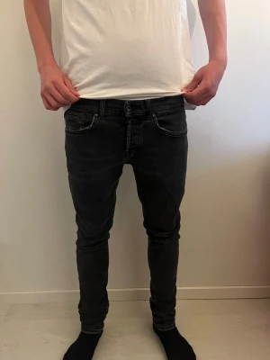 Svarta skinny jeans med stretch - Säljer ett par svarta skinny jeans med stretch från Dondup i storlek 31. Jeansen har smal passform, låg midja och diskreta slitningar för en trendig look. Perfekta för dig som gillar en tajt stil och vill ha bekväma jeans till vardags. Priset kan diskuteras!