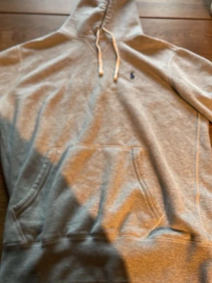 Grå hoodie från Polo Ralph Lauren - Snygg grå hoodie från Polo Ralph Lauren köpt för prick ett år sedan i affären men var för stor så har haft på den ungefär 2 gånger utomhus så helt ny nästan  