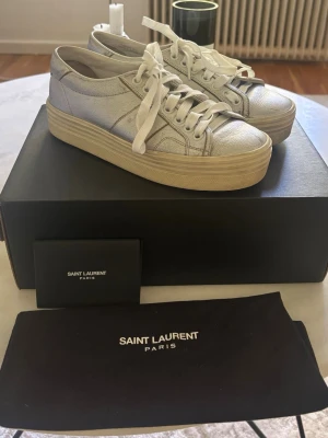 Sneakers YSL  - Gråa skinn sneakers från Saint Laurent. Box, dustbag, certifikat medföljer. Skorna är använda, men väl omhändertagna. Unika sneakers som ingen annan har, så snygga! Säljes då de e något förstora. Storleken är 36,5 men jag tycker mer de drar åt 37. Lyxiga snygga sneakers till bra pris! Nypris 5000:- prislapp kvar på kartongen!