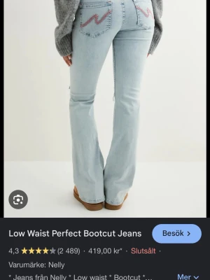 Bootcut jeans med låg midja från Nelly - Ljusa bootcut jeans med låg midja från Nelly. Jeansen har slitningar vid knäet och broderade detaljer på bakfickorna. Tillverkade i ljusblå denim med klassisk femficksdesign och dragkedjegylf. Inga större defekter bara lite rivna längst ner, inte så jätte använt men måste låta gå nu.
