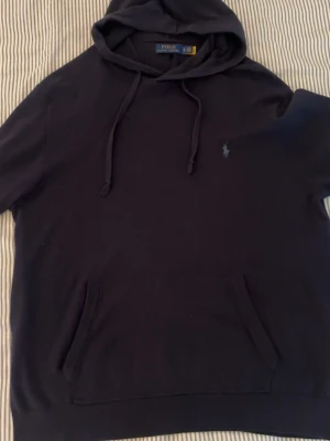 Mörkblå Polo Ralph lauren Hoodie - Mörkblå Polo Ralph Lauren hoodie i mjuk och skön merinoull✨ Riktigt fet passform och sitter sjukt snyggt på kroppen. Perfekt både till vardag och mer uppklädda outfits, samtidigt som den är enkel att matcha. Storlek XLarge och i fint skick 🔥  Vid intresse är det bara att lägga ett bud eller skriva vid minsta fråga eller fundering 💬