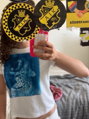Vit t-shirt med blått leopardtryck - Snygg vit t-shirt med croppad passform och ett stort blått tryck av en leopard på framsidan. Perfekt för dig som vill sticka ut med ett coolt djurmotiv. T-shirten har korta ärmar och rund halsringning. Aldrig andvänd 