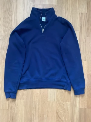 Mörkblå halfzip sweatshirt från Zara - Mörkblå sweatshirt med halfzip och hög krage från Zara. Tröjan har en avslappnad passform, långa ärmar och ribbade muddar. Mycket bra skick (9/10) Nypris ~600. Priset är inte hugget i sten!!
