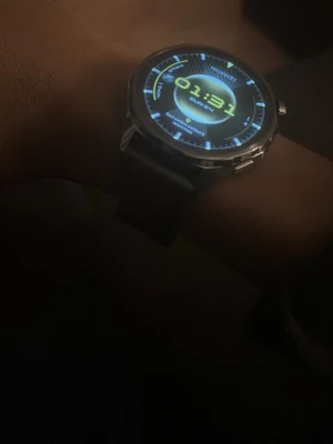 Huawei smartklocka med svart armband medföljer box - Snygg smartklocka från Huawei med rund urtavla och digital display. Klockan har ett svart silikonarmband och metallram runt skärmen. Modern design med tydlig display och gula detaljer på urtavlan. Perfekt för dig som vill ha koll på tiden och notiser direkt på handleden den är helt ny och fungerar perfekt.