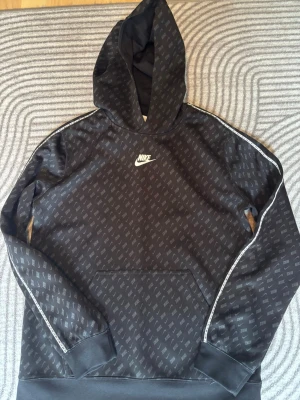 Svart Nike hoodie med logomönster - Snygg svart Nike hoodie i barn storlek 158-170cm pris går att diskutera 