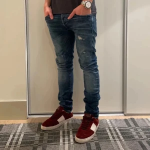Jack & Jones jeans med slitningar - Snygga blå jeans med slitna detaljer från Jack & Jones. Storlek W30 L32. Lånad bild ifrån han jag köpte de av, säljer för de inte passar mig så bra. Skriv vid funderingar. OBS! Finns ett hål vid knät