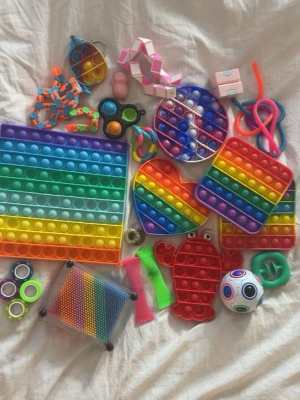 Stort paket med fidget toys - Säljer ett mixat paket med fidgetleksaker i olika former och färger, bland annat regnbågsfärgade pop it i hjärta, cirkel, fyrkant och krabba, stressbollar, kuber, snurror och stretchy leksaker. Materialet är mestadels silikon och plast. Perfekt för dig som gillar att pilla och hålla händerna sysselsatta.Går att köpa alla eller styckvis såklart  💕