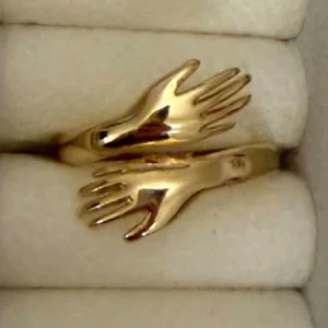 Guldfärgad ring med handmotiv - Unik guldfärgad ring i  med två händer som möts framtill. Ringen har en modern och lekfull design som sticker ut och passar perfekt för dig som gillar coola accessoarer.