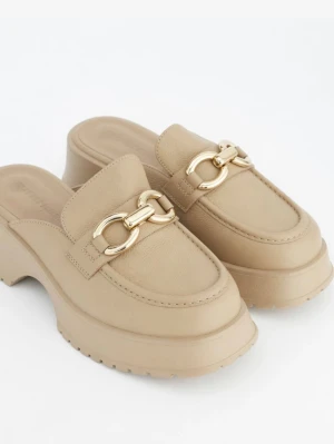 Chunky beige loafers med gulddetalj - Säljer ett par chunky beige loafers med kraftig sula och guldfärgad kedjedetalj framtill i konstläder. Helt nya och såklart oanvända.