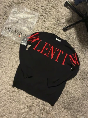 Svart tröja med röd VALENTINO-logga - Helt ny Snygg svart tröja från Valentino strl XL men sitter som L, passar till alla outfits och är väldigt bekväm tröja inför sommaren! Kan gå ner i pris vid snabb affär. Frågor, tveka inte!👍