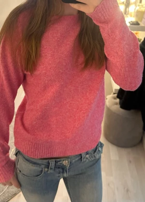 Rosa stickad tröja med rund hals - Mysig rosa stickad tröja med rund halsringning och ribbade muddar vid ärmslut och nederkant. Perfekt för lager-på-lager och enkel att matcha med jeans eller kjol. Tröjan har en klassisk passform och är superbekväm.