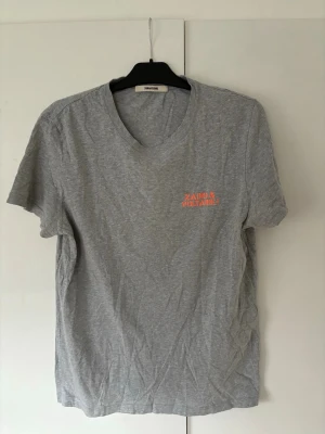 Zadig Voltaire t-shirt herr M - Sjukt snygg eftertraktad t-shirt från Zadig Voltaire i storlek M säljes. Perfekt nu till sommaren och grym passform. Inga hål eller fläckar i använt men mycket mycket bra skick!