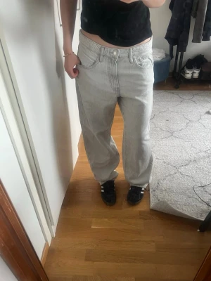 Baggy ljusgrå jeans med raka ben - Säljer ett par baggy ljusgrå jeans med raka ben och klassiska fem fickor. Jeansen har låg midja och bred passform, perfekta för en avslappnad streetstil. Materialet är denim i bomull. Snygga att matcha med sneakers och t-shirt. Jeansen är också stora i storleken, så passar även större storlekar.