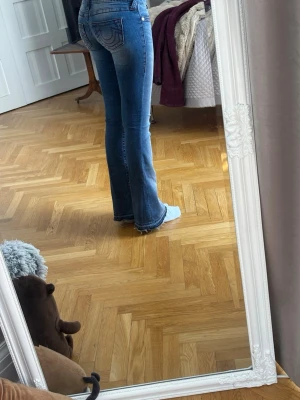 True Religion jeans - Blåa True Religion jeans som jag har sprättat upp vid ändarna vilket gör dem pyttelite längre än den vanliga modellen. Jeansen är lågmidjade och bootcut. Trådarna har gått upp lite på vänster bakficka som man kan se på bild🩷🌸