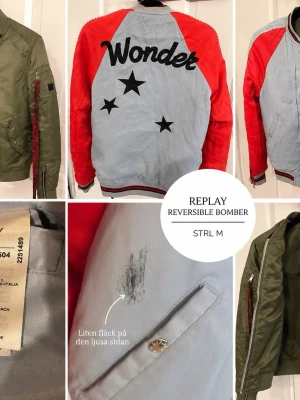 Reversibel bomberjacka Replay M - Cool reversibel bomberjacka från Replay i storlek M. Ena sidan är olivgrön med klassisk bomberstil och silvriga dragkedjor, andra sidan är ljusgrå med röda ärmar, svarta stjärnor och texten 'Wonder' på ryggen. Randiga muddar och snygga detaljer.