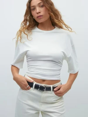 Vit topp från gina - Säljer en vit croppad topp. Toppen har en rund halsringning och är gjord i mjuk bomull, perfekt för en avslappnad och trendig look. Enkel att matcha med både jeans och kjol.