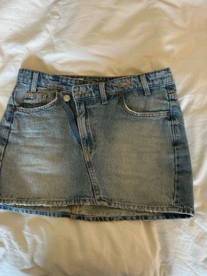 Blå jeanskjol i kort modell - Snygg jeanskjol från Zara men därmed sne dragkedjedesign som gör kjolen lite unik. Säljer då den tyvärr inte kommer till användning längre🩷