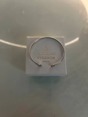 Caroline svedbom - Använd 2 gång. Tycker inte det är min stil därför säljer jag den. Jättefin och jättesöt. Den är justerbar. 🥰🥰 Inga skador eller repor, lådan kommer med. 😊