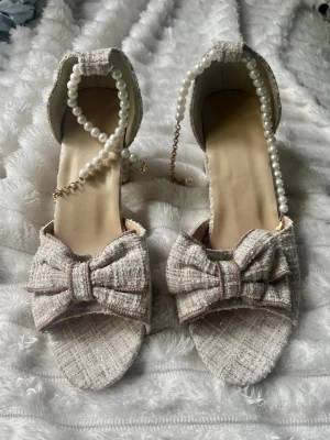 Beiga sandaler med pärlband och rosett - Vackraste klackarna jag äger men som ej kommit till användning. 🌸 i storlek 39! 🎀
