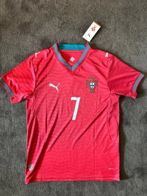 Portugal VM 26/27 hemma Ronaldo 7 - Fotbollströja med Ronaldo på ryggen. Tröjan är helt ny med tagg kvar och i perfekt skick. Perfekt för dig som är supporter, samlar på fotbollströjor eller vill ha en snygg tröja till träning och vardag.                                                                     🔻 Skickas inom 24 timmar.                                         Vid intresse eller frågor är det bara att skicka 👍