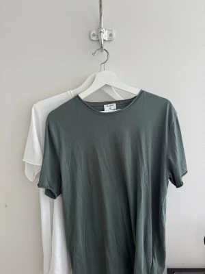 Två T-shirts från Filippa K - Säljer två Filippa K Roll Neck Tee t-shirts i storlek M, en mörkgrå och en vit.  Köpta för ca 10 månader sedan och sparsamt använda. Kvitto medföljer. Nypris 600 kr/st.