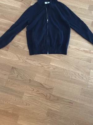 Kashmir hoodie - Mysig mörkblå zip hoodie från Sayless i mjuk cashmere. Koftan har dragkedja framtill, hög krage och långa ärmar. Perfekt för dig som gillar stilrena och bekväma plagg med exklusiv känsla.