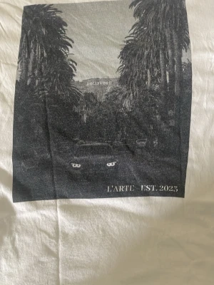 Vit t-shirt L'Arte med tryck - Vanlig vit tröja med snyggt tryck på baksidan.
