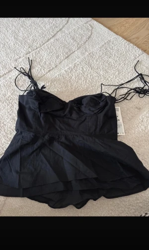 Svart topp med snörning från zara  - Supersnygg populär svart topp från zara. Den är helt ny och då aldrig använd. Passar perfekt nu till sommaren! Den är i stolek L men passar även M skulle ja tro. Skriv om ni har frågor💓🙌🏻