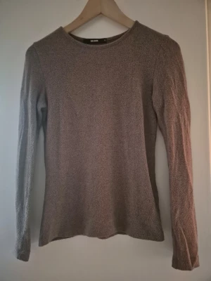 Ljusbrun tunnstickad tröja från Bik Bok stl.XS - Mysig ljusbrun stickad tröja från Bik Bok i storlek XS. Tröjan har rund halsringning, långa ärmar och är tillverkad i ett mjukt material som passar perfekt till kyligare dagar. Enkel och stilren design som är lätt att matcha.