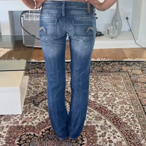 G star jeans  - Säljer mina kära G star jeans eftersom att dom inte längre passar mig🥹första två bilderna är från förra säljaren (köptes via plick ca 2024 och använda väl sedan dess). De är fortfarande i förvånansvärt bra skick förutom små defekter som längst ner på benen, se bild! De är väldigt Low waist med classy bootcut. Skulle gissa att de är ca storlek xxs-xs! Beroende på önskad passform💝 priset är förhandlingsbart!