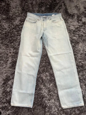 Ljusblå loose jeans - Säljer ett par ljusblå jeans med loose passform och klassisk femficksdesign. Jeansen har en avslappnad vibe och är perfekta för en casual look. Tillverkade i denim med snygg tvättad effekt och normal midja.