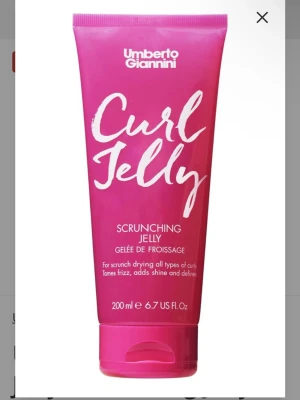 Umberto Giannini Curl Jelly 200ml - Umberto Giannini Curl Jelly är en rosa gelé för lockigt hår (funkar säkert som vanligt gel för slickbacks osv) som hjälper till att tämja friss, ge glans och definiera lockar. Kommer i en mjuk plasttub på 200 ml med vit text och praktiskt snäpplock. Oanvänd