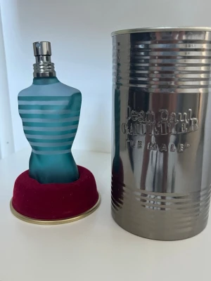 Jean Paul Gaultier Le Male parfym - Ikonisk parfymflaska formad som en manlig torso i frostat blått glas med vita ränder. Kommer med original metallburk med präglad logga. En klassiker från Jean Paul Gaultier som sticker ut i badrumshyllan. 50 ml flaska ca 10 ml kvar 