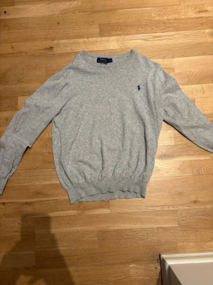 Polo - Tja! Säljer en fin Polo tröja i skönt material, färgen grå med den fina mörkblå loggan. Tröjan kommer i storlek M men är ganska kort så skulle säga att den passar bra till S eller även XS.