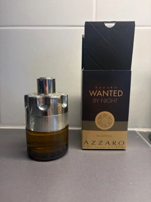 Azzaro Wanted By Night parfym 100ml - Azzaro Wanted By Night Eau de Parfum i en cool, maskulin flaska med metallisk silverdetalj och brungul glasbotten. Parfymen kommer i originalkartong och rymmer 100 ml. Doften är intensiv och passar dig som gillar att sticka ut.
