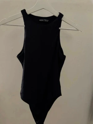 Svart body från SHEIN - Svart body från SHEIN med rund halsringning. Tillverkad i mjukt och stretchigt material som sitter skönt mot kroppen. Ny utan prislapp. 