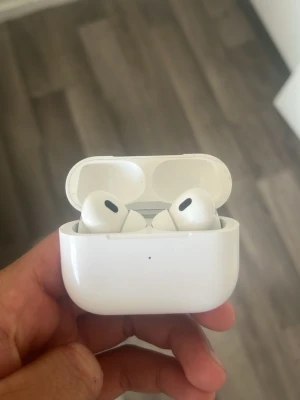 Apple AirPods Pro med laddningsetui - Säljer ett par vita Apple AirPods Pro med trådlöst laddningsetui. Snygg och kompakt design i blank plast, in-ear-modell med silikontoppar och brusreducering. Perfekt för musik, samtal och träning. Laddningsetui med magnetlock och LED-indikator. Airpodsen är 2a generationen och är använda. Du kar riktigt bra och laddas med iPhone laddare!