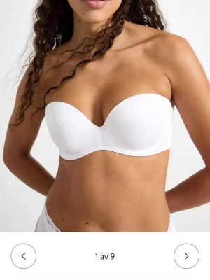 Ny! Vit axelbandslös bh med avtagbara band Lindex  - Snygg vit axelbandslös bh med släta kupor och avtagbara, justerbara axelband som kan korsas i ryggen. Perfekt under toppar och klänningar med bara axlar. Mjuk och stretchig materialblandning för skön passform. Nypris 349;-