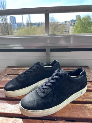 Svarta Axel Arigatos i mocka - Säljer dessa snygga sneakers från Axel Arigato. De är i en klassisk svart färg. Skorna är minst sagt i bra skick men finns fortfarande tecken på användning. Skorna är i mocka och storlek 44. Hör av dig vid frågor eller funderingar! 
