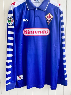 Gabriel Batistuta - Florentina - Långärmad matchtröja - Säljer en klassisk fotbollströja, Gabriel Batistutas långärmade Fiorentina-matchtröja. Tröjan är en reprint i nyskick.  Storlek: XL men liknar mer L/XL