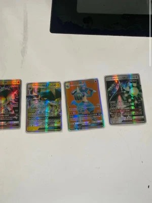 Pokémon GX holografiska samlarkort - Fyra coola Pokémon GX holografiska samlarkort: Buzzwole GX, Vikavolt GX, Lucario GX och Celesteela GX. Korten har färgstarka motiv och glansig yta, perfekta för samlare eller Pokémon-fans som vill utöka sin kortlek.